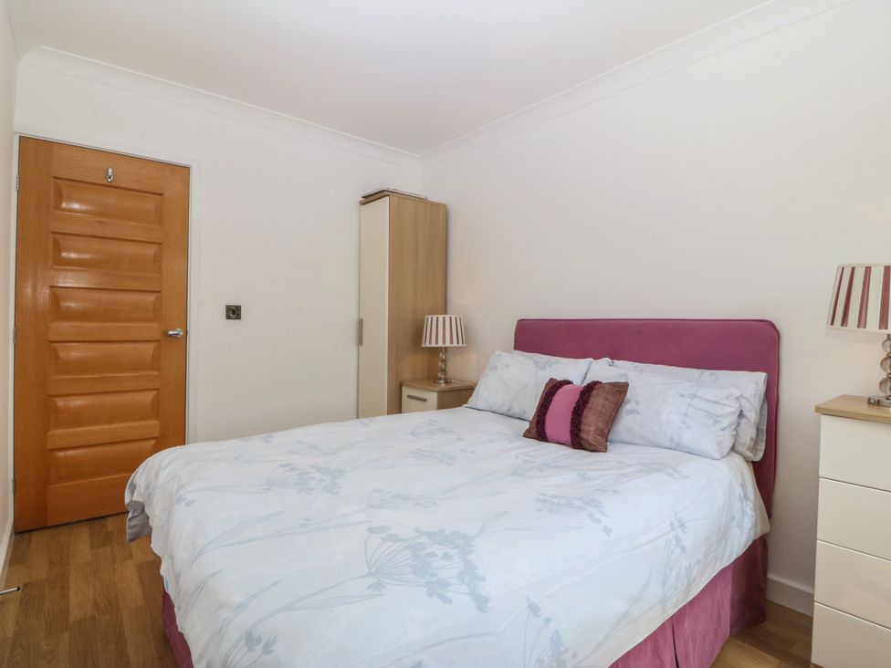 A bedroom with a bed and bedside lamp at Hillside in 
