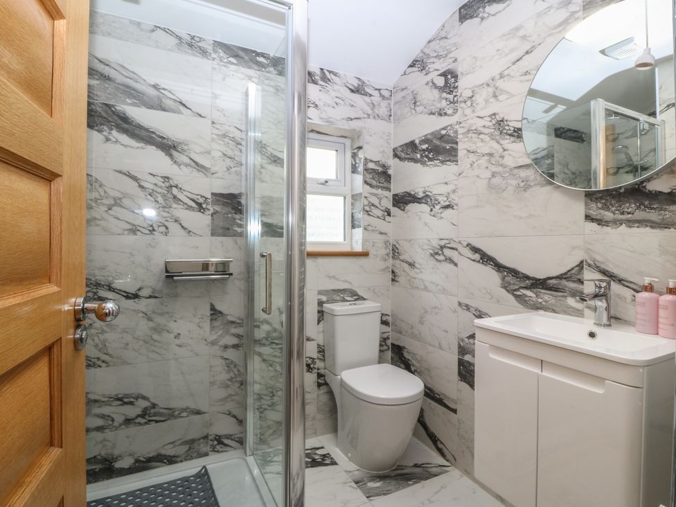 A bathroom with a shower, toilet, and sink at Hillside