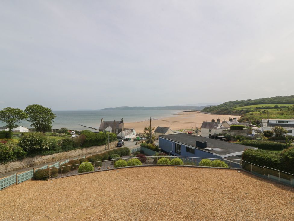 A view of the sea and beach with houses and trees at Hillside in 