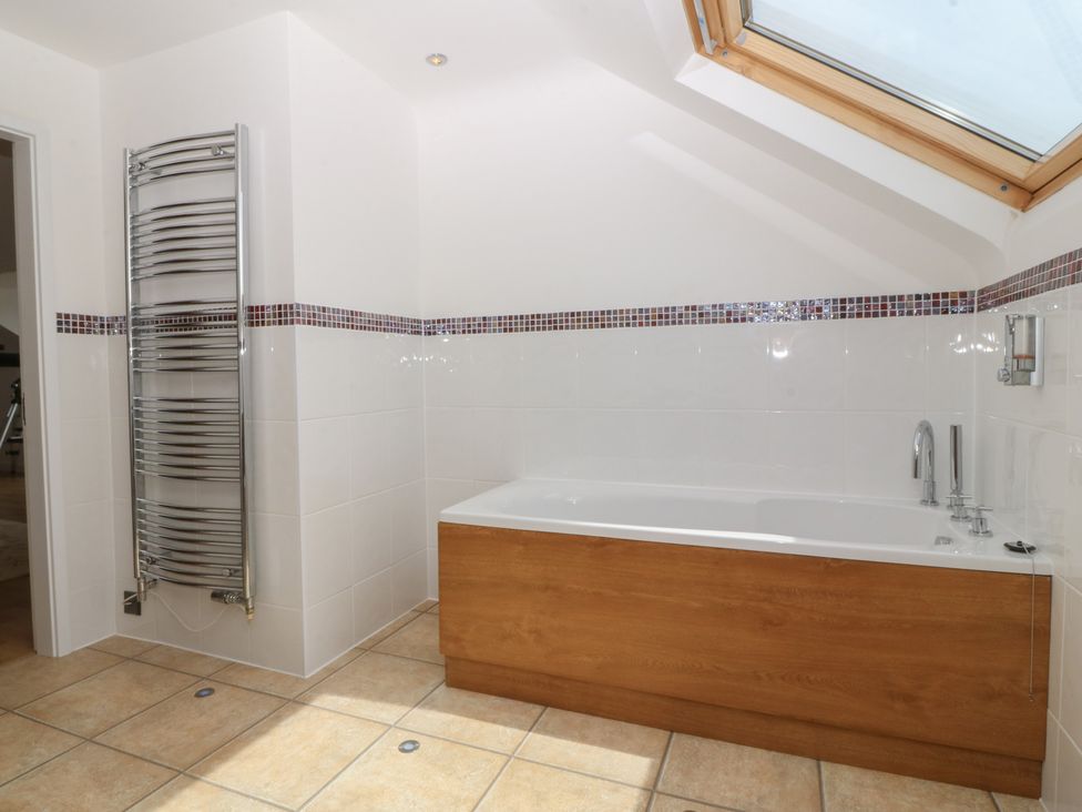 A bathroom with a bath tub and towel radiator at Hillside