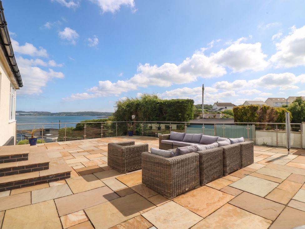 An outdoor terrace with seating overlooking water at Hillside