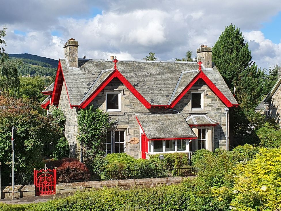 A house with a stone exterior and red accents at Edengrove in Aberfeldy