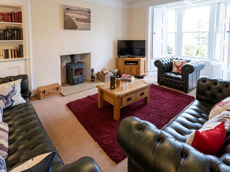 A living room with a television and a coffee table at Edengrove in Aberfeldy
