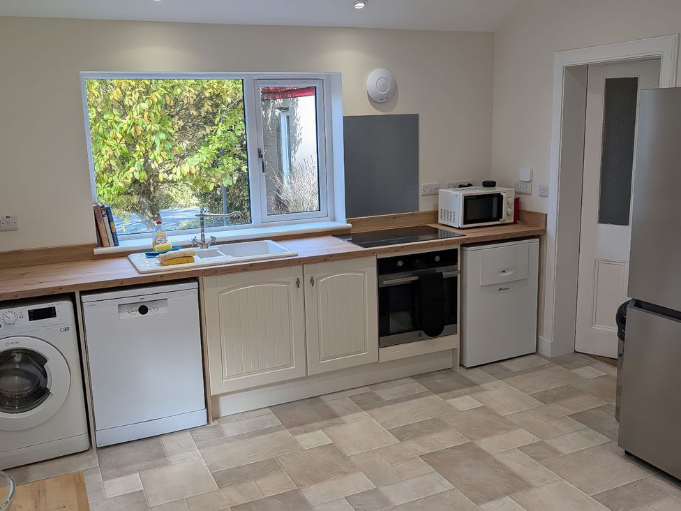 A kitchen with appliances and a window at Edengrove Aberfeldy
