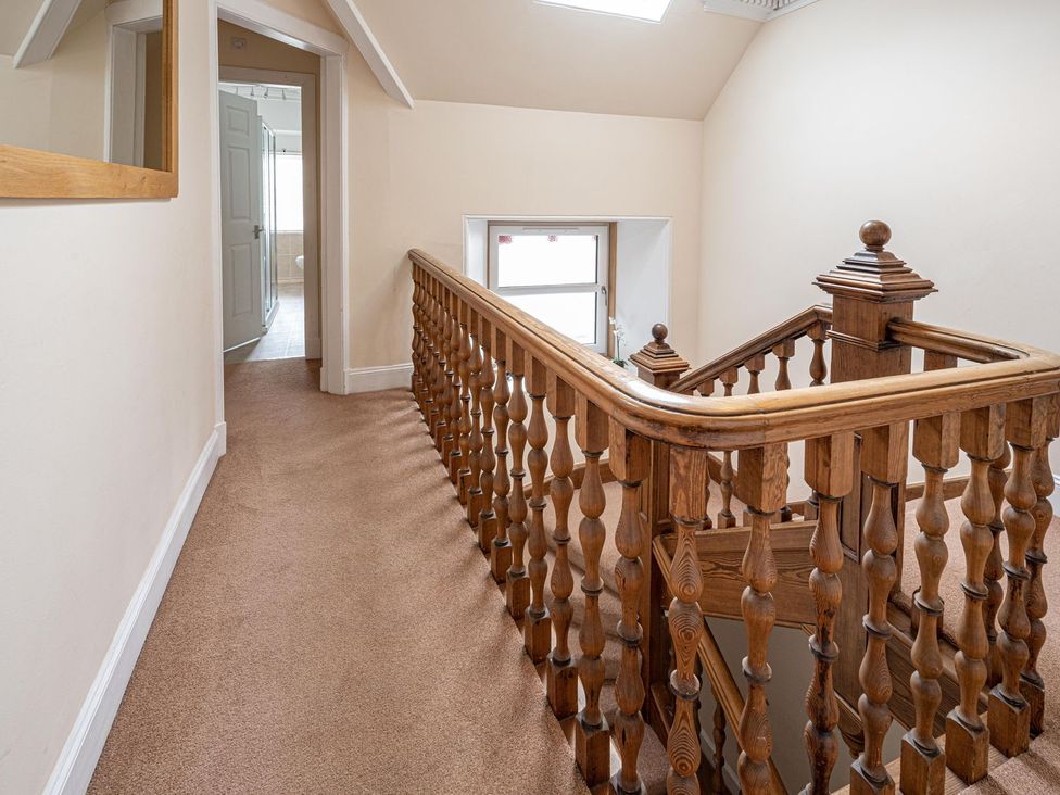 A hallway with a staircase and railing at Edengrove in Aberfeldy