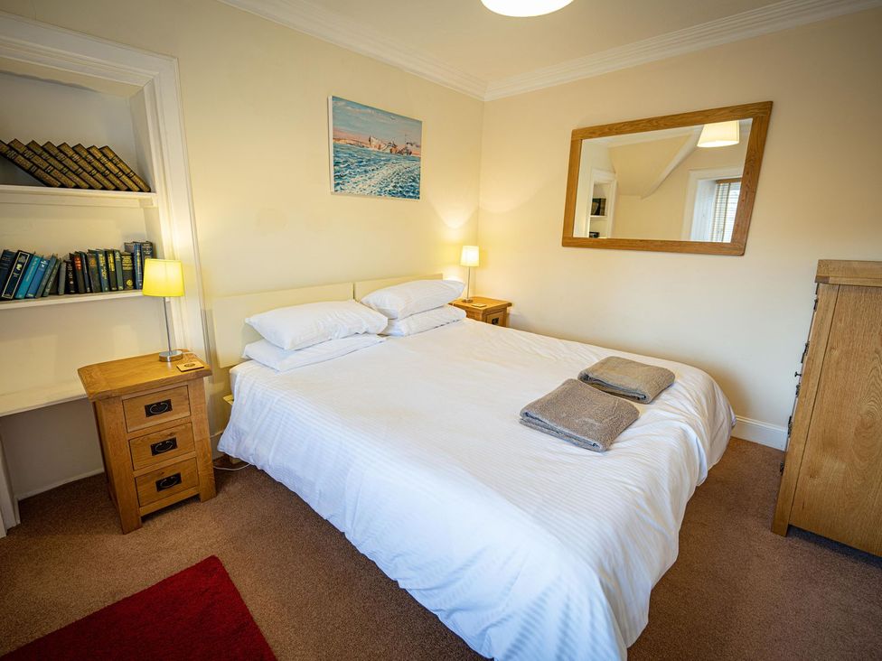 A bedroom with a bed and books on a shelf at Edengrove Aberfeldy