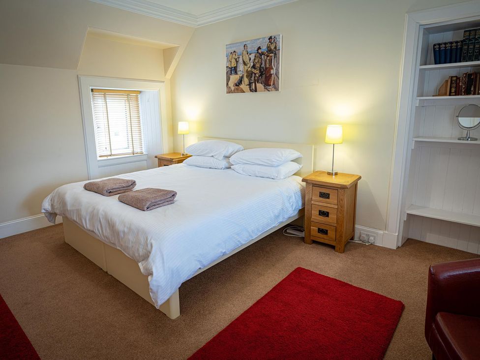 A bedroom with a bed and nightstands at Edengrove in Aberfeldy