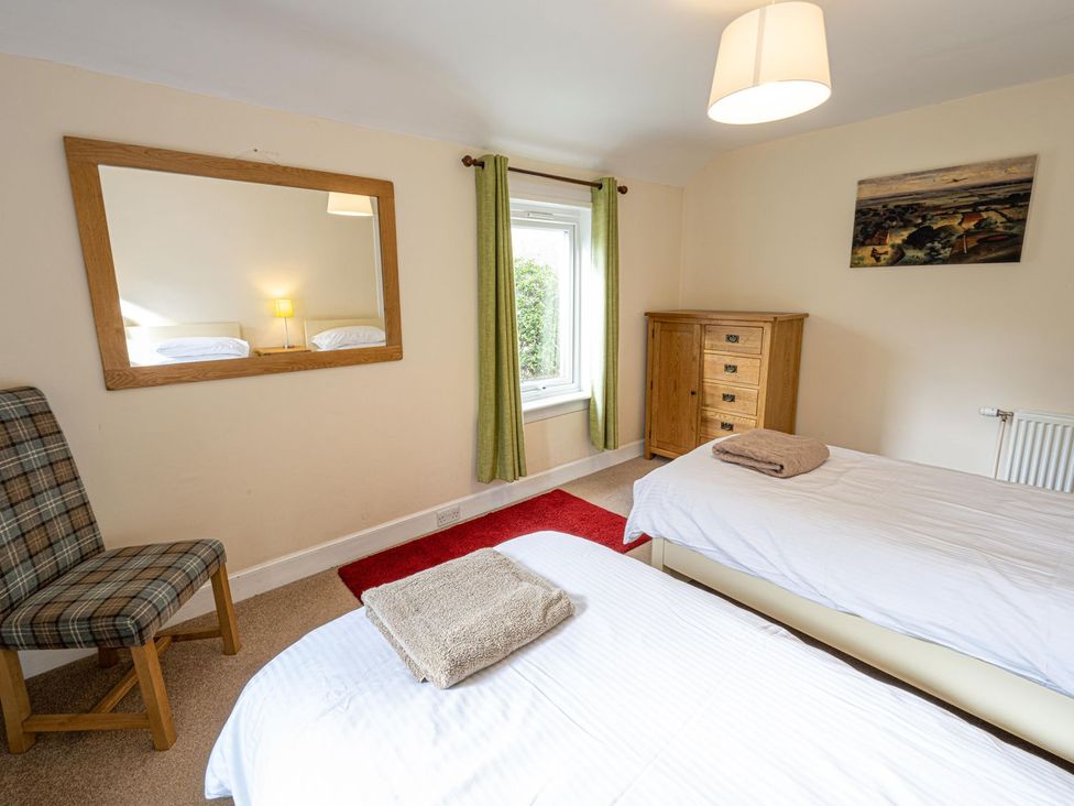 A bedroom with two beds and furniture at Edengrove in Aberfeldy