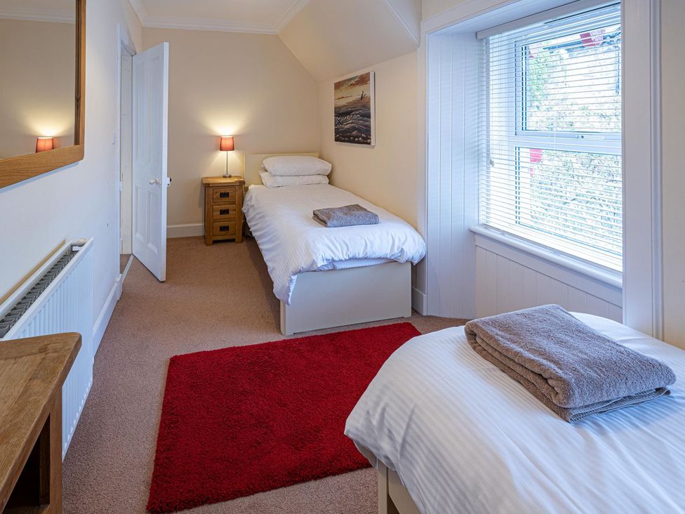 A bedroom with two beds and a window at Edengrove Aberfeldy