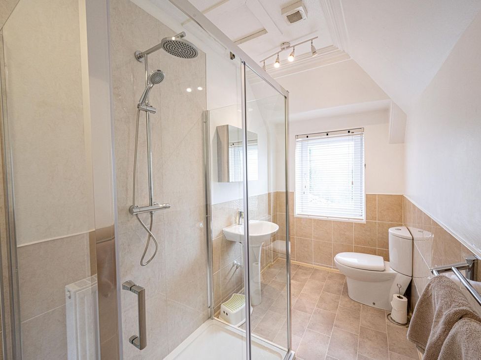 A bathroom featuring a shower, toilet, and sink at Edengrove in Aberfeldy