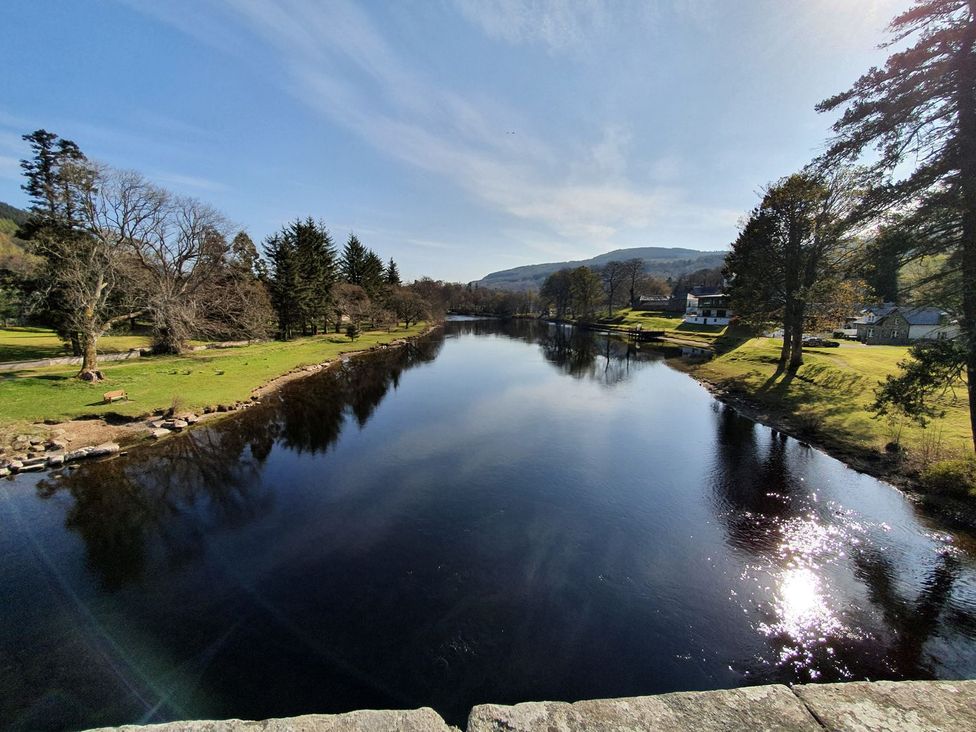 A river with trees and houses at Edengrove Aberfeldy