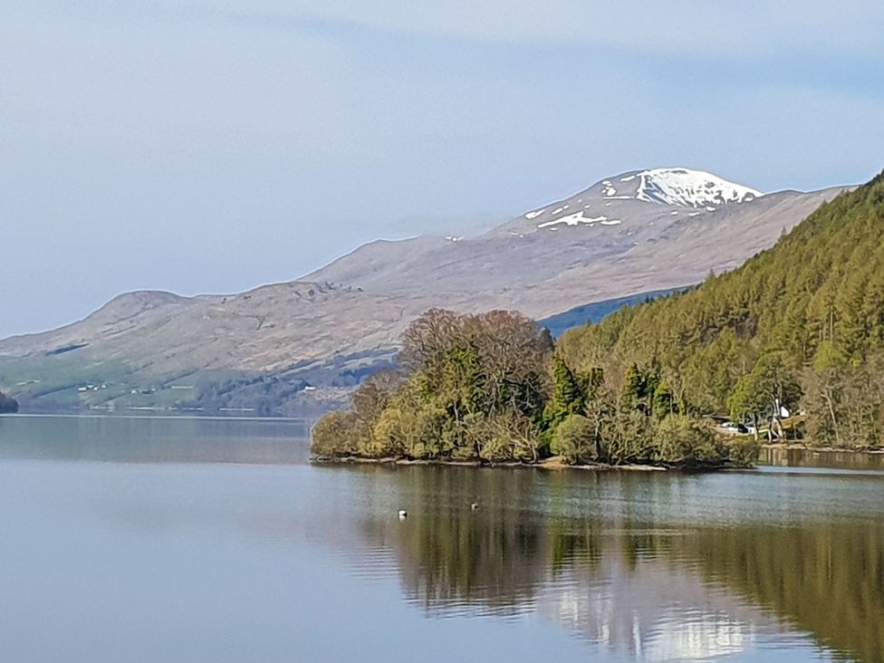 A view of a lake with mountains and trees at Edengrove Aberfeldy