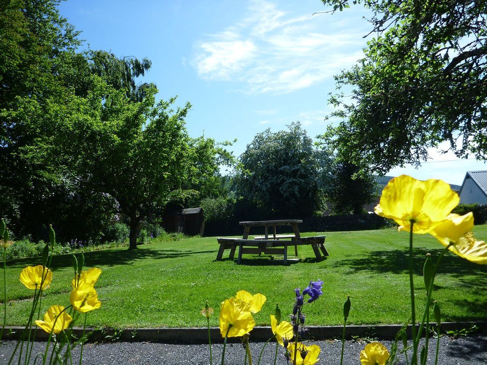 A garden with a picnic table and flowers at Edengrove in Aberfeldy