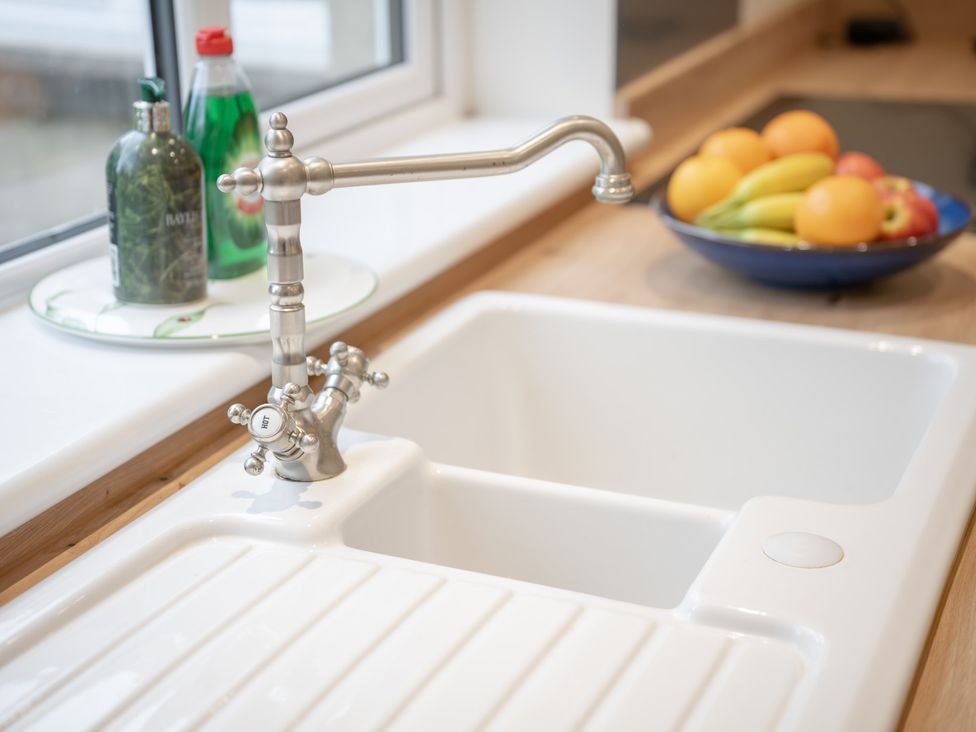 A kitchen with a tap and sink near a bowl of fruit at Edengrove in Aberfeldy