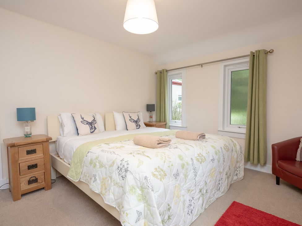 A bedroom with a bed and nightstand at Edengrove in Aberfeldy