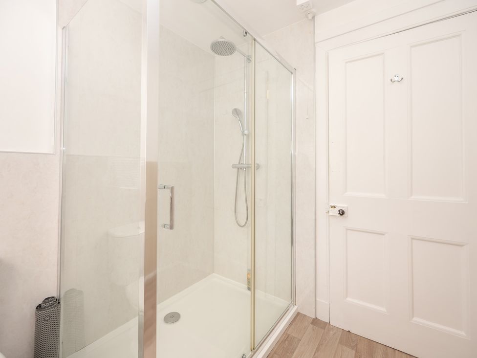 A bathroom with a shower and a door at Edengrove Aberfeldy