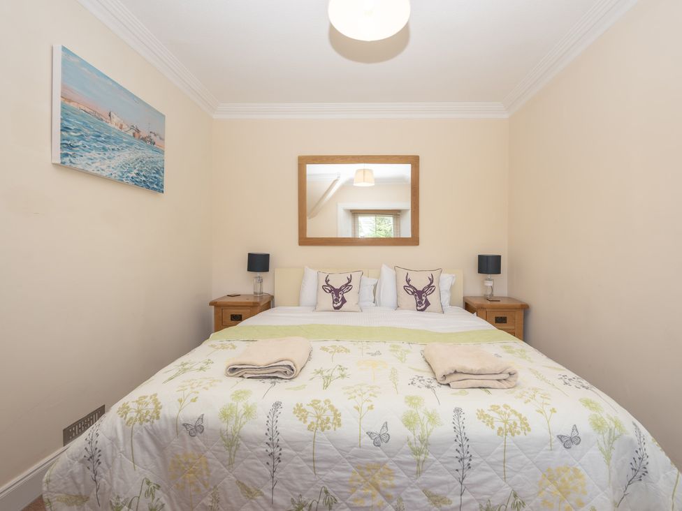 A bedroom with a double bed and artwork on the wall at Edengrove in Aberfeldy