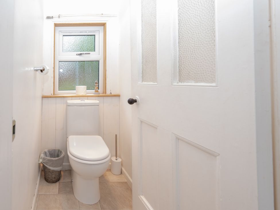 A bathroom with a toilet and window at Edengrove in Aberfeldy