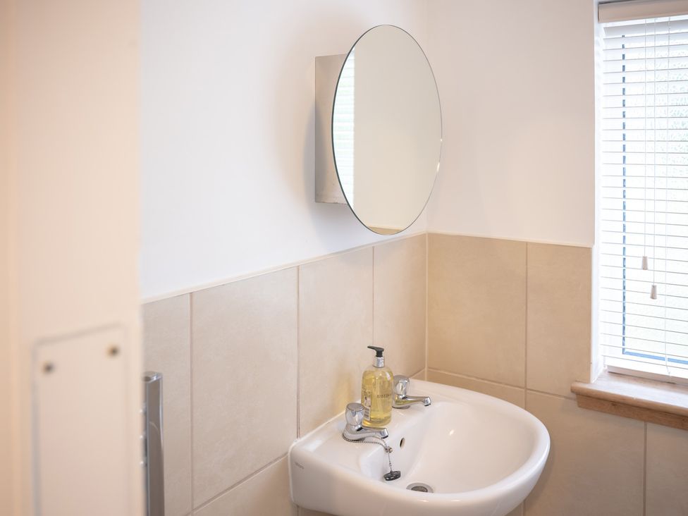 A bathroom with a sink and mirror at Edengrove Aberfeldy