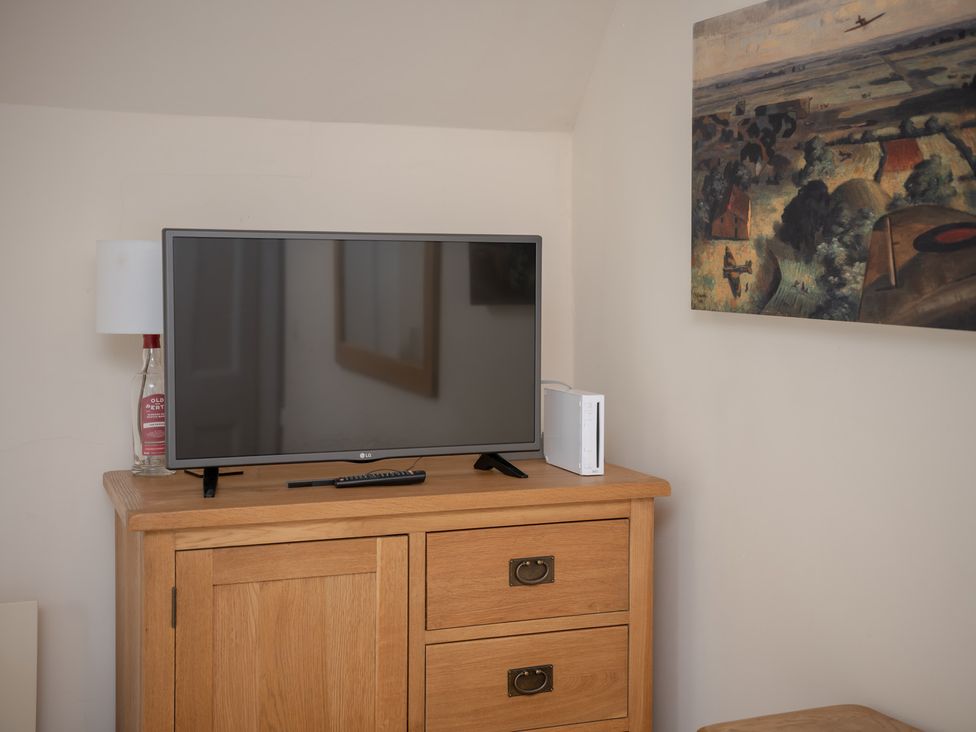 A television and lamp on a drawer unit in a bedroom at Edengrove Aberfeldy