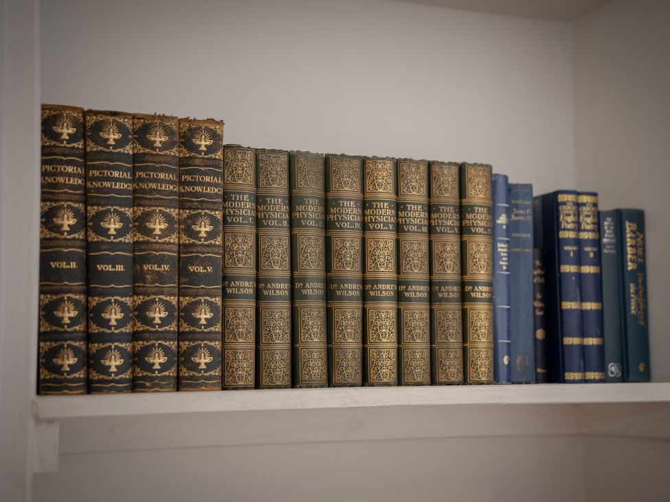 A collection of antique books on a shelf at Edengrove in Aberfeldy