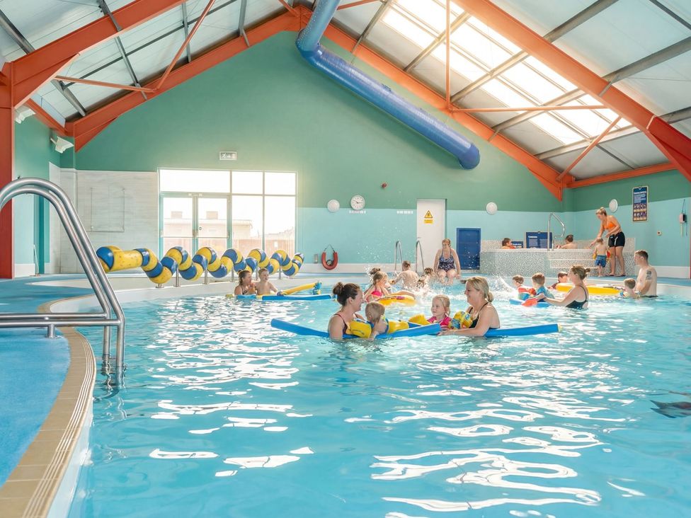 A swimming pool with children and adults at Tide’s Reach - Hayling Island