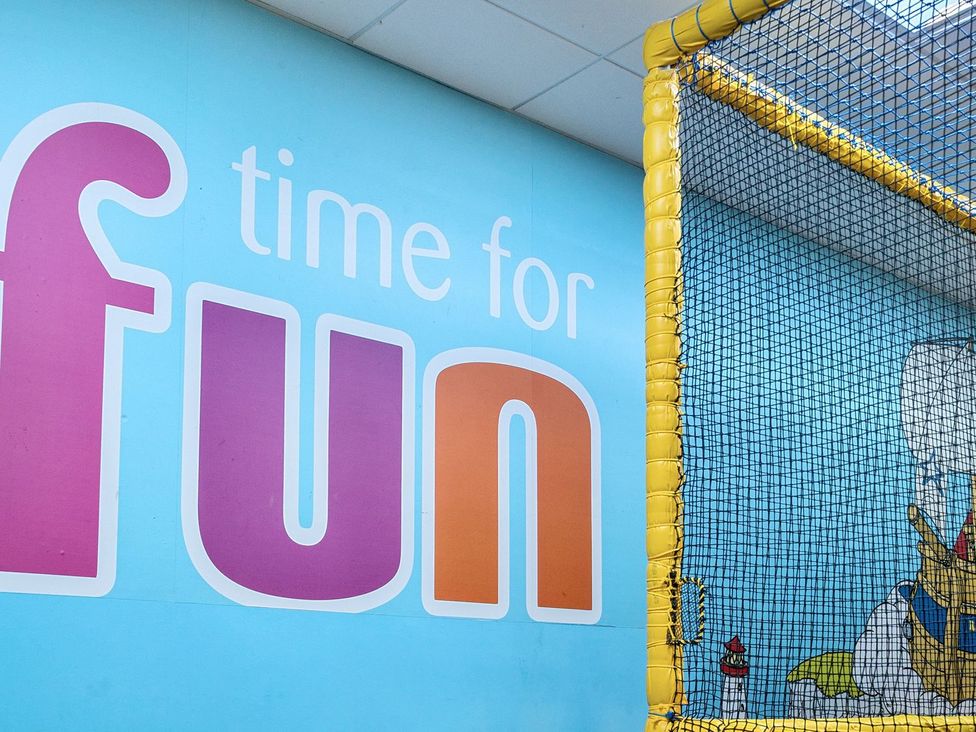 A play area with a net and a wall saying time for fun at Tide’s Reach - Hayling Island