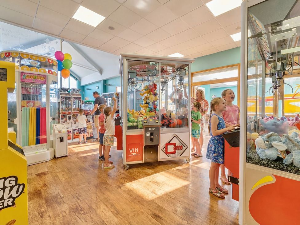 A group of children interacting with arcade games at Tide’s Reach - Hayling Island
