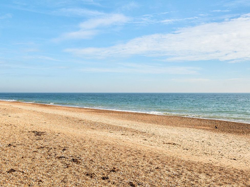 A beach with sand and ocean waves at Tide’s Reach - Hayling Island