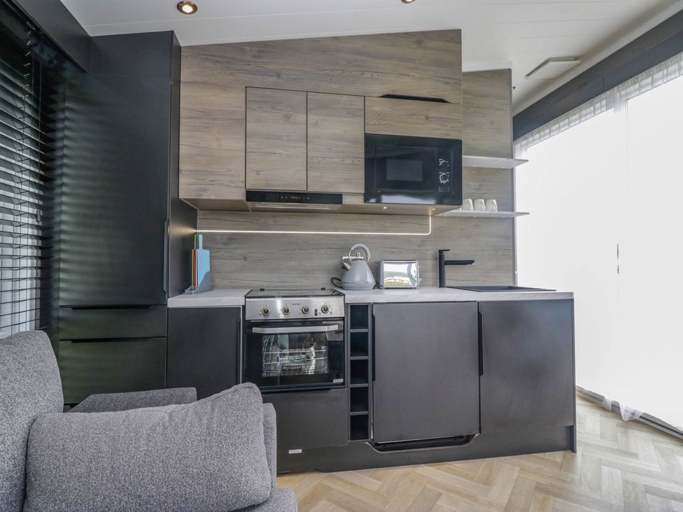 A kitchen with cabinets and appliances at Heron in Haverigg