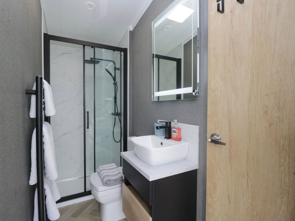 A bathroom with a shower and sink at Heron Haverigg
