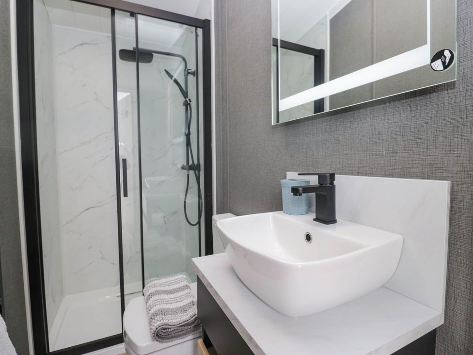 A bathroom with a shower and sink at Heron in Haverigg