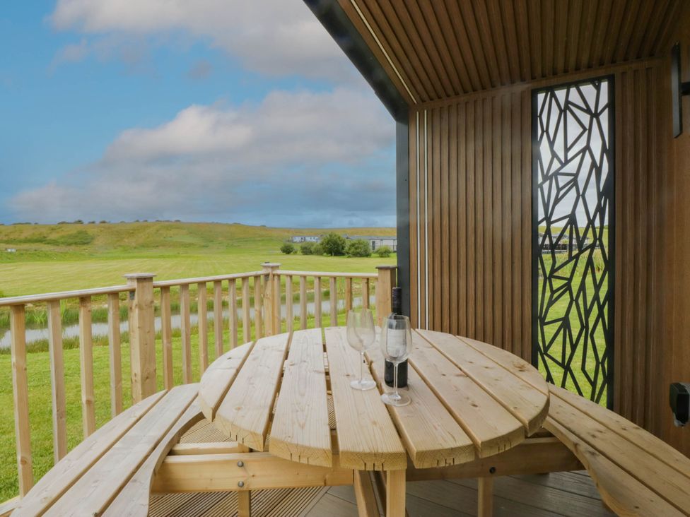 An outdoor area with a table and glasses at Heron in Haverigg