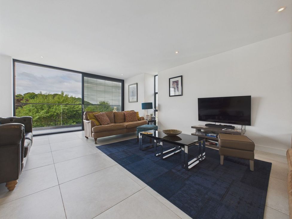 A living room with a sofa and a television at Oakwood House in Tansley near Matlock