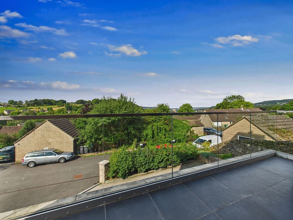 A view from a balcony overlooking houses and greenery at Oakwood House Tansley near Matlock