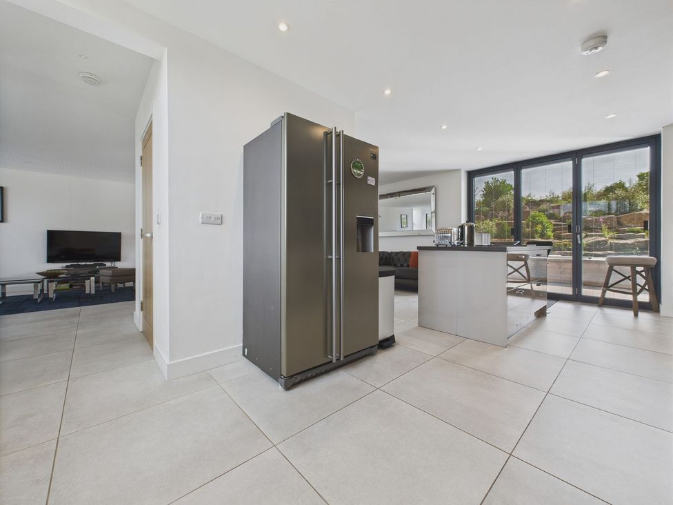 A kitchen with a refrigerator and kitchen island at Oakwood House in Tansley near Matlock