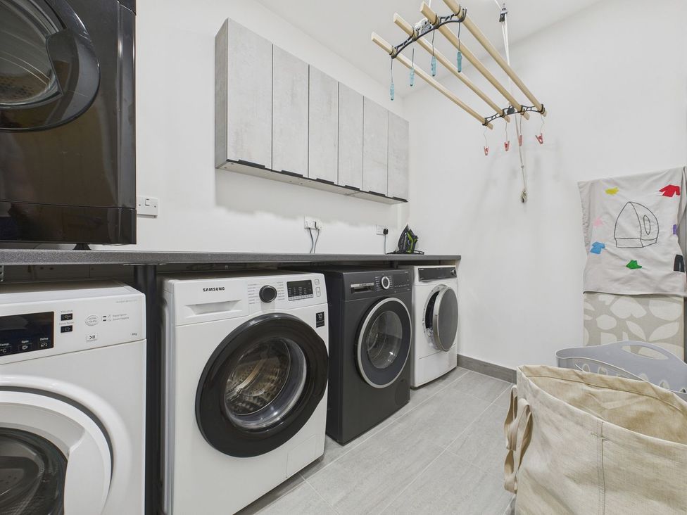 A laundry room with washing machines and a drying rack at Oakwood House in Tansley near Matlock