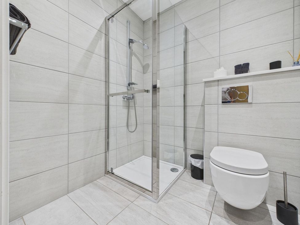 A bathroom with a shower and toilet at Oakwood House in Tansley near Matlock