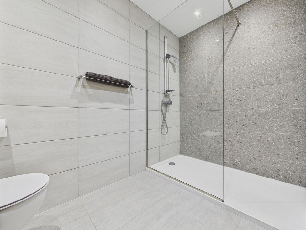 A bathroom with a shower and toilet at Oakwood House in Tansley near Matlock