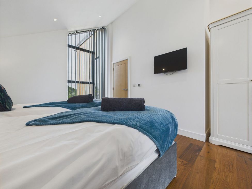 A bedroom with a bed and television at Oakwood House in Tansley near Matlock