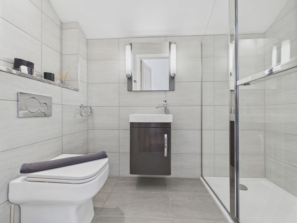 A bathroom with toilet, sink, and shower at Oakwood House in Tansley near Matlock