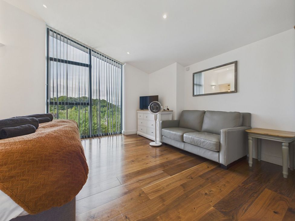 A bedroom with a bed sofa and television at Oakwood House Tansley near Matlock