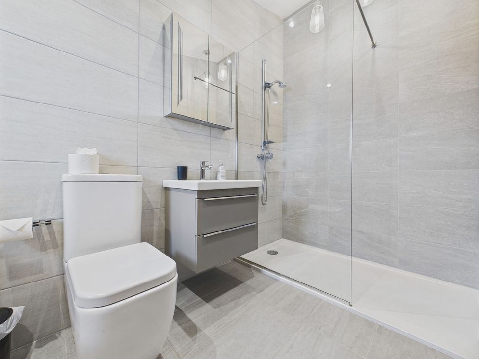 A bathroom with a shower and sink at Oakwood House in Tansley near Matlock