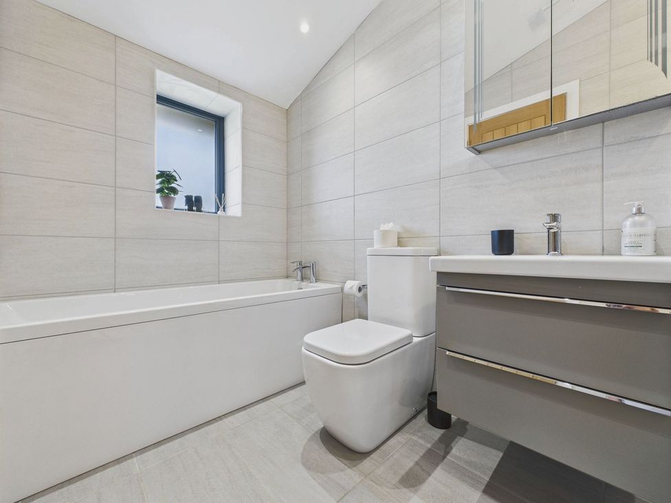 A bathroom with a bathtub, toilet and sink at Oakwood House in Tansley near Matlock