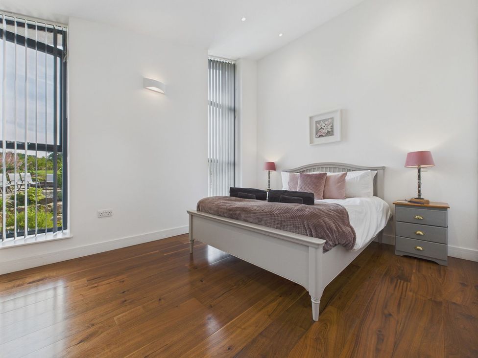 A bedroom with a bed and nightstand at Oakwood House Tansley near Matlock