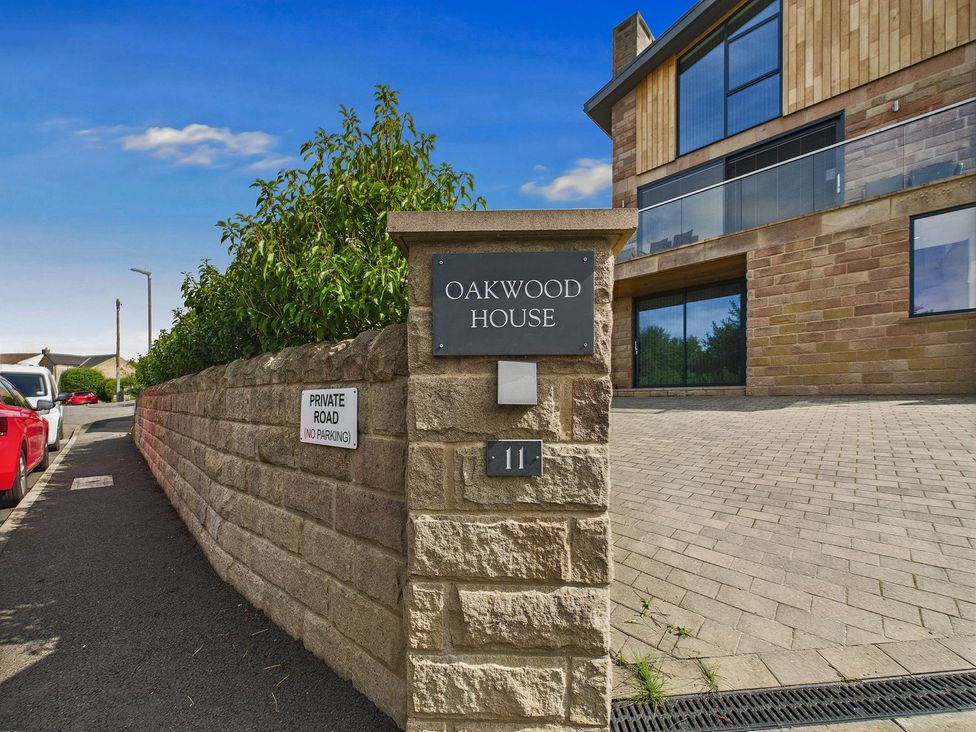 An exterior view of Oakwood House with a sign and a parking indication in Tansley near Matlock
