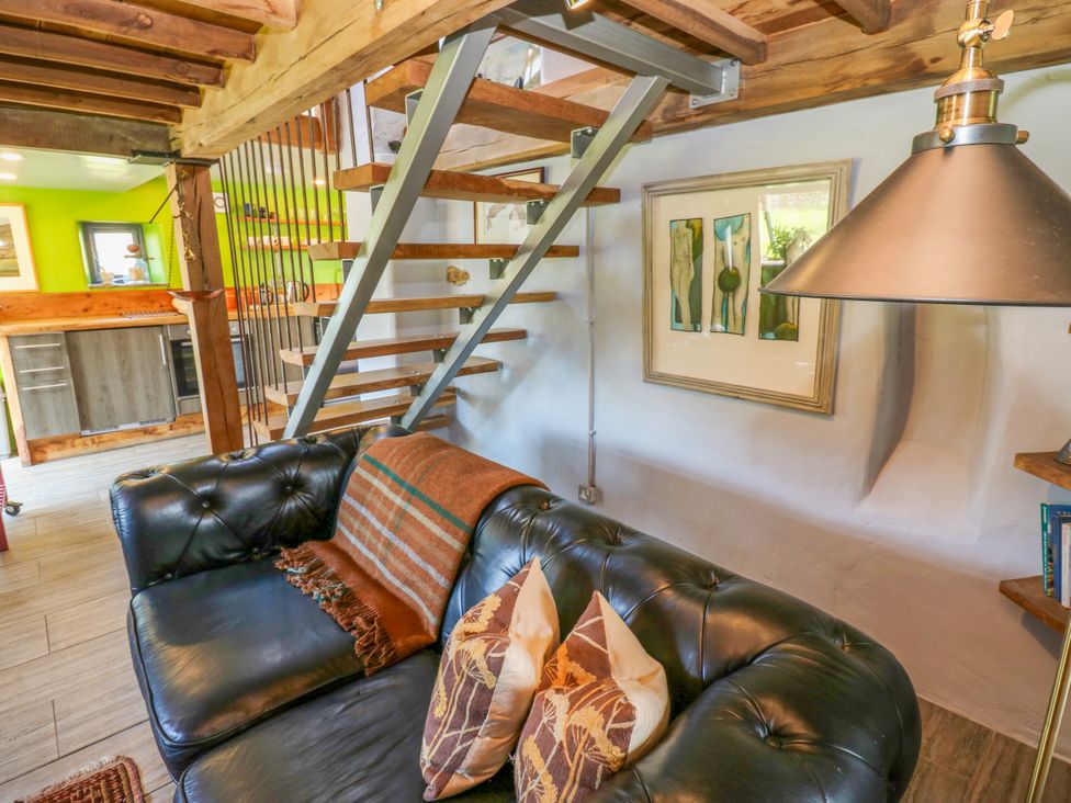A living room with a sofa and stairs at The Brew House in Penrith