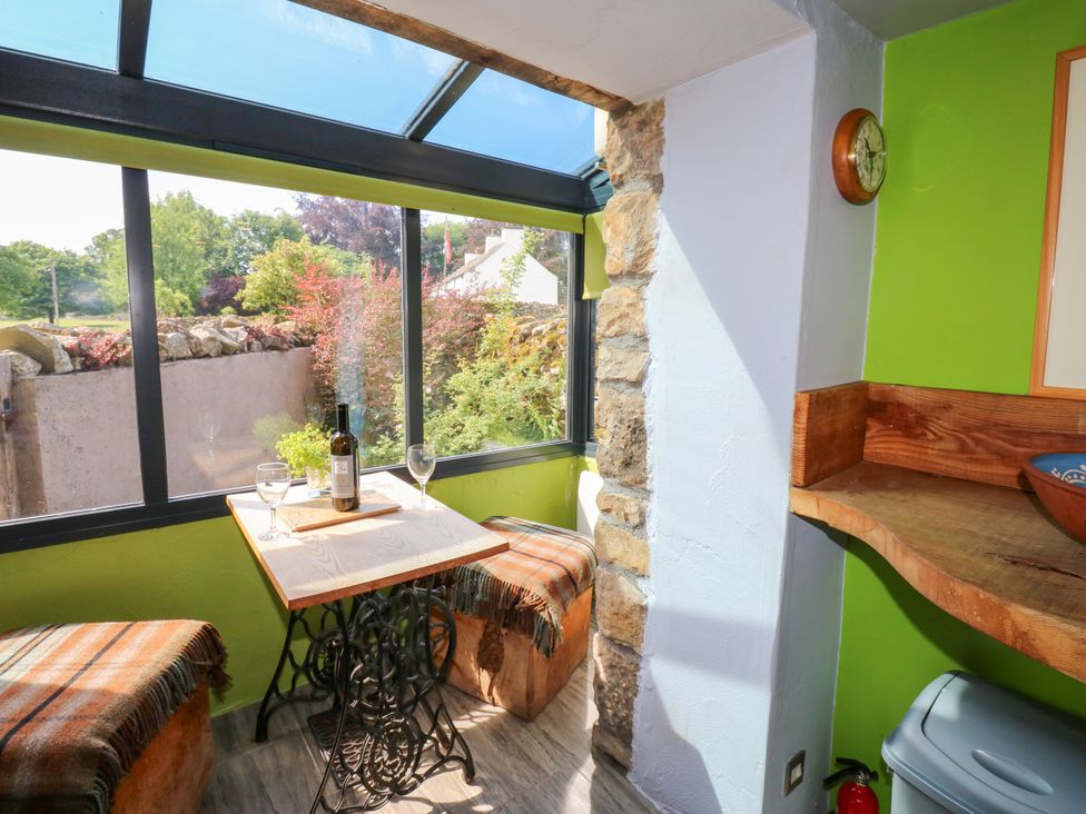 A conservatory with a table and wine glasses at The Brew House in Penrith