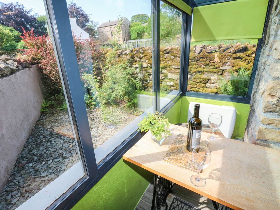 A conservatory with a table and wine bottle at The Brew House in Penrith
