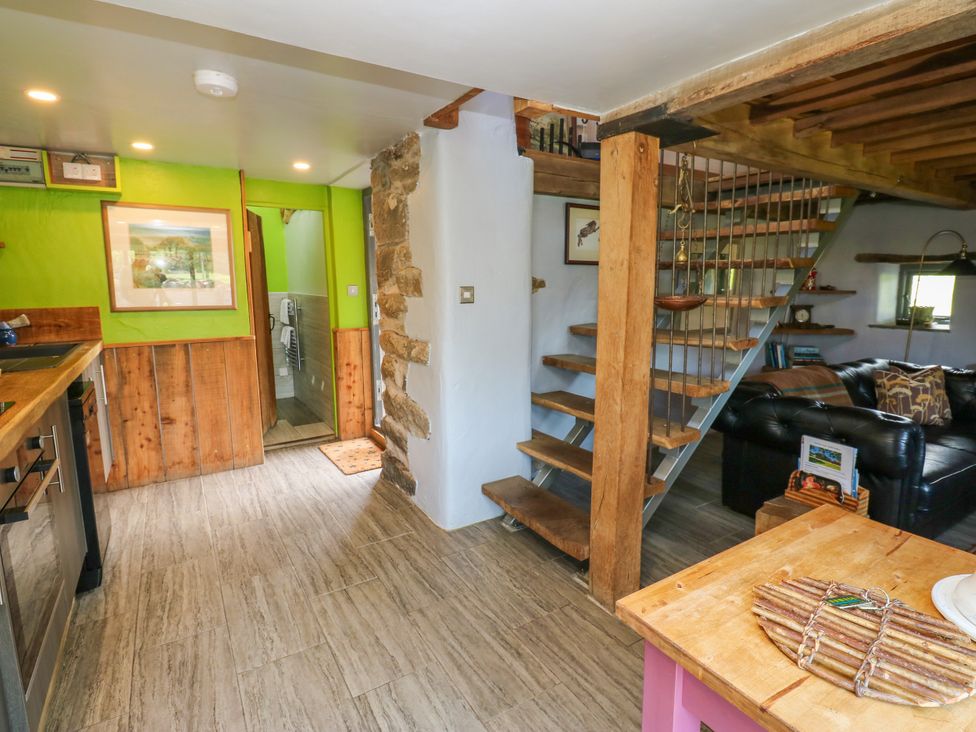 A living room with a staircase and kitchen area at The Brew House in Penrith